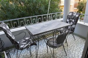 een tafel en stoelen op een balkon bij Classy apt. Sokratous in Athene