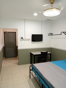 a hospital room with a bed and a table and a television at Hotel Seri Intan Tampin in Tampin