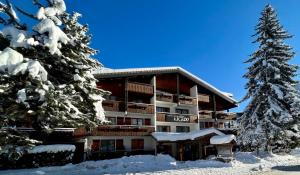 um hotel na neve com árvores cobertas de neve em Hôtel Igloo em Morzine