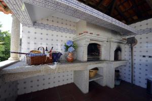 uma cozinha com uma lareira de pedra num quarto em Villa 320 em Barcelos