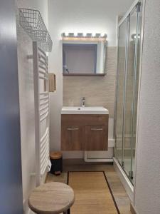 a small bathroom with a sink and a stool at Studio rénové - Pied des pistes - Prapoutel - Les 7 laux in Les Adrets