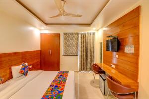 a bedroom with a bed and a desk and a tv at Hotel Aroma Residency Premium Sector 47 Family Friendly in Gurgaon