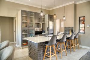 a kitchen with a large island with bar stools at Highland Gate Eagles Breeze in Dullstroom