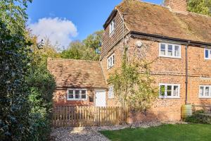 an old red brick house with a wooden fence at Host & Stay - Bere Cottage in Canterbury