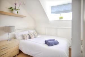 um quarto com uma cama branca e uma toalha roxa em Seaside spacious 4 BR Nr Town centre and Open Golf em West Kirby