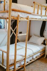 a couple of bunk beds in a room at Dar Sultana Guesthouse Surf Morocco in Tamraght Oufella