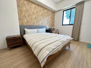 a bedroom with a bed and a table and a window at 9 Tan Yuan Homestay in Jiaoxi