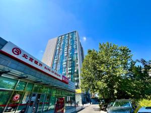 a building with a sign on the side of a street at Beijing Lesiure Aparment - 200M from Exit D of Line 6 in CBD in Beijing