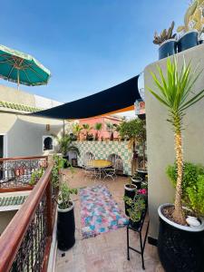 einen Balkon mit Topfpflanzen und eine Terrasse mit einem Tisch in der Unterkunft Riad Hna Ben Saleh in Marrakesch