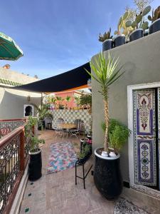 eine Terrasse mit einem Tisch und einer Topfpflanze in der Unterkunft Riad Hna Ben Saleh in Marrakesch