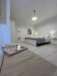 a white bedroom with a bed and a rug at B&B Due Su Due Holiday in Vietri sul Mare