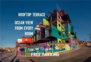 a building covered in graffiti on the side of a road at Hotel Winebox Valparaiso in Valparaíso