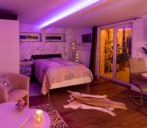 a purple bedroom with a bed and a table at Unser Studio-Apartment "Wohlfühloase" in Oranienburg