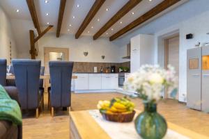 eine Küche mit einem Tisch mit einer Vase Obst darauf in der Unterkunft Ferienwohnung Harzliebe - am Fuße des Brocken in Wernigerode
