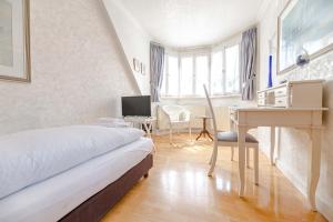 a bedroom with a bed and a desk and a computer at Hotel Leone d´Oro in Heidelberg