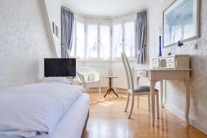 a bedroom with a bed and a desk with a computer at Hotel Leone d´Oro in Heidelberg