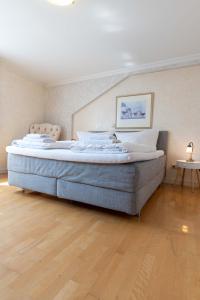 a large bed in a room with a wooden floor at Hotel Leone d´Oro in Heidelberg