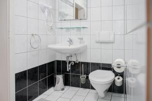 a white bathroom with a toilet and a sink at Hotel Leone d´Oro in Heidelberg