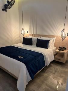 Schlafzimmer mit einem großen Bett mit blauer und weißer Bettwäsche in der Unterkunft HOTEL MASS LUXURY in Doradal