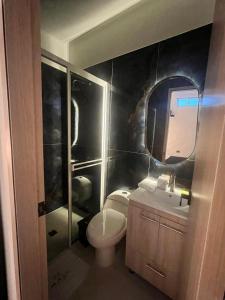 ein Badezimmer mit einem WC, einem Waschbecken und einem Spiegel in der Unterkunft HOTEL MASS LUXURY in Doradal