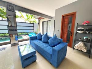 a living room with a blue couch and a glass table at Deja View in Jimbaran