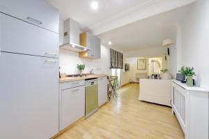 Il comprend une cuisine avec des placards blancs et du parquet. dans l'établissement Fontanella Borghese CORI apartment, à Rome