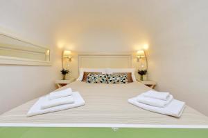 - un grand lit blanc avec 2 serviettes blanches dans l'établissement Fontanella Borghese CORI apartment, à Rome