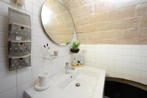 une salle de bains avec un lavabo blanc et un miroir dans l'établissement Fontanella Borghese CORI apartment, à Rome 28 autres photos