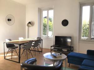 a living room with a table and a blue couch at White light, 1 minute à pied du Port! in Nice