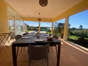a dining room with a table and chairs on a patio at Pôr-do-sol Villa in São Pedro do Corval