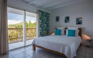 - une chambre avec un lit et une grande fenêtre dans l'établissement Saint Barth Villa 2, à Saint-Jean