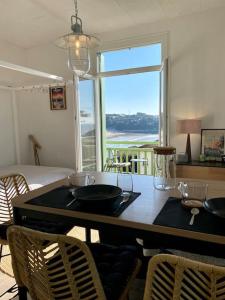 a dining room with a table with chairs and a window at Studio lumineux vue mer et plage avec balcon in Saint-Palais-sur-Mer