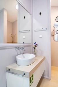 a white bathroom with a sink and a mirror at Boutique house with Pateo in Sintra