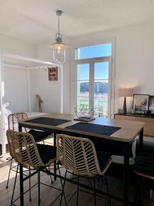 a dining room with a table with chairs and a window at Studio lumineux vue mer et plage avec balcon in Saint-Palais-sur-Mer