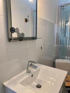 a white bathroom with a sink and a mirror at Studio lumineux vue mer et plage avec balcon in Saint-Palais-sur-Mer