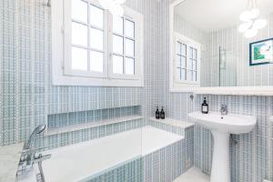 uma casa de banho com uma banheira e um lavatório em Entire Villa 430 sqm - 17 bedrooms, 19 beds, Villa des Ammonites em Meudon