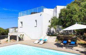 a swimming pool with two chairs and an umbrella at Villa Mare in Corbara