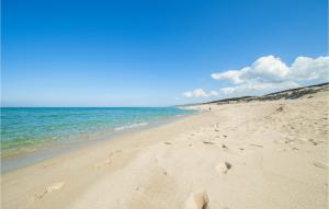 einen Strand mit Fußabdrücken im Sand und im Ozean in der Unterkunft La Pietraia in Badesi
