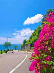 a street with pink flowers on the side of the road at Muong Thanh Son Tra Apartment Seaview Da Nang in Da Nang