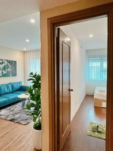 an open door to a living room with a blue couch at Muong Thanh Son Tra Apartment Seaview Da Nang in Da Nang