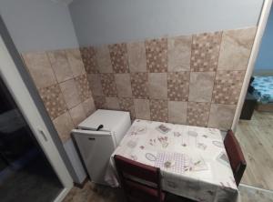 Cette petite chambre comprend une table et un petit réfrigérateur. dans l'établissement Toshevo Guests, 