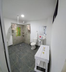 uma casa de banho branca com um WC e um lavatório em Finca Hostal La Esperanza em Quimbaya