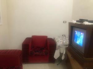 sala de estar con sofá y TV en برنس, en Marsa Matruh