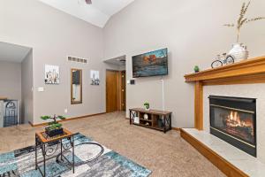 een woonkamer met een open haard en een televisie bij Oak Haven: 3 King Beds + Fast Wi-Fi + FREE Parking 