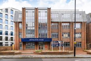 un gran edificio de ladrillo con una casa azul de bienvenida en New Modern 1 Bed Flat Great Location Piccadilly Line, en Hounslow