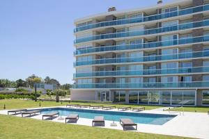 un gran edificio con una piscina frente a él en Oceana Suites en Cruceros III, con piscina interior climatizada, en Punta del Este