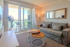 una sala de estar con un sofá y una mesa en Oceana Suites Cruceros III, en Punta del Este