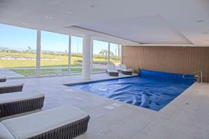 una gran piscina en una habitación con sillas en Oceana Suites Cruceros III, en Punta del Este