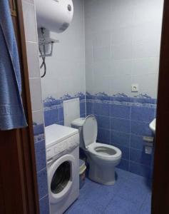 a bathroom with a toilet and a washing machine at Apartment near the airport - Квартира около аэропорта in Dushanbe