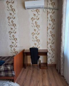 a bedroom with a desk and a black chair at Apartment near the airport - Квартира около аэропорта in Dushanbe